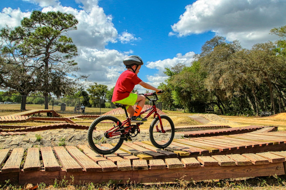 man in green shirt riding on bicycle during daytime