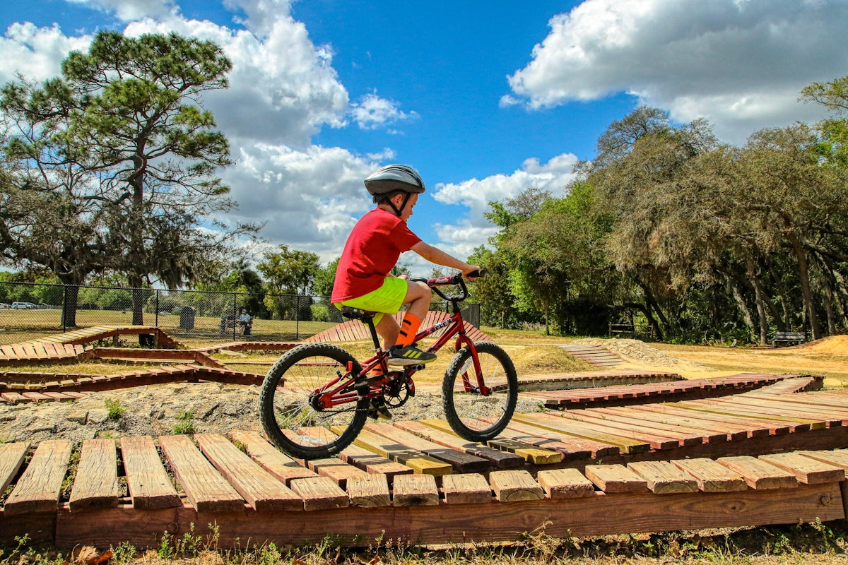 man in green shirt riding on bicycle during daytime