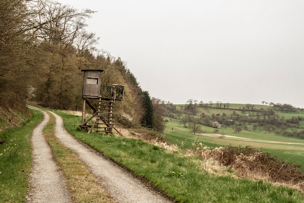 Wooden hunting blind on a dirt road with rolling hills